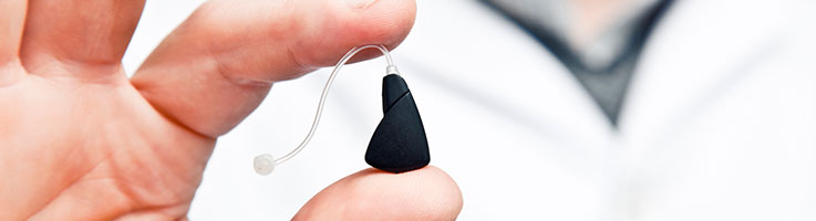 person holding a hearing aid