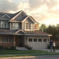 a couple standing in front of a two story house