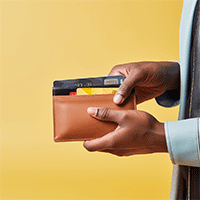 hands of a man holding a wallet with several bank cards in it