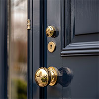 image showing a golden door knob and lock on a black door