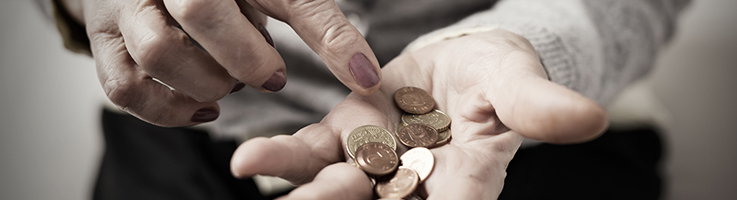 older woman counting coins in her hand