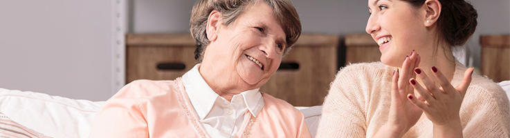 elderly woman laughing with young woman