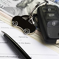 car key remote on top of money and documents
