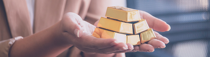 gold bars stacked in womans hands