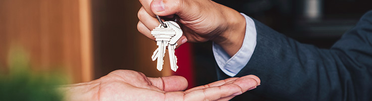 person handing their house key to a friend
