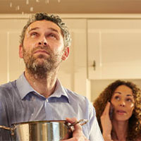 family looking at leaking water from ceiling