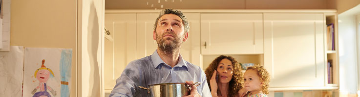 family looking at leaking water from ceiling