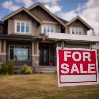 a two story house with a house for sale sign in the front