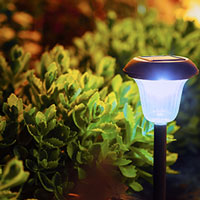solar-powered lamp in front of flower bed