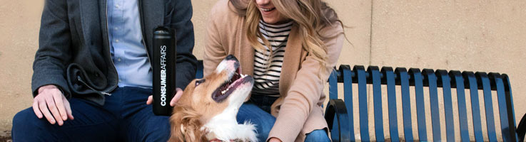 dog and two people sitting on bench