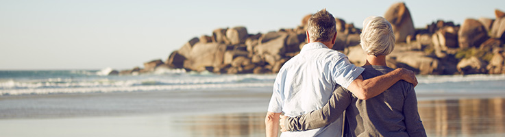 older couple walking on a beach