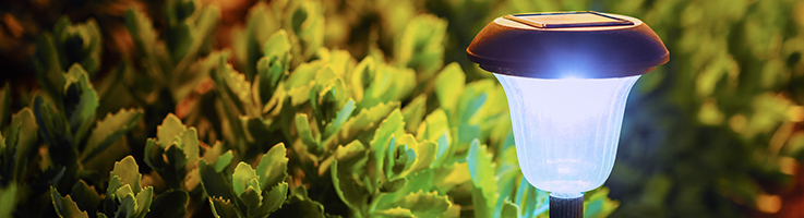 solar-powered lamp in front of flower bed