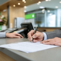 a man signing documents at a bank
