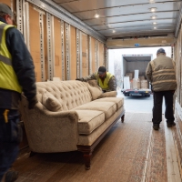 movers moving a couch on a truck