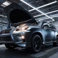 a metallic gray Lexus SUV inside a garage with its hood open