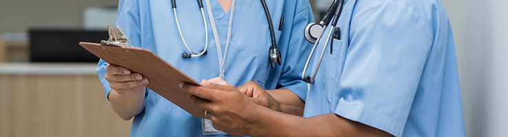 two nurses looking over a clipboard