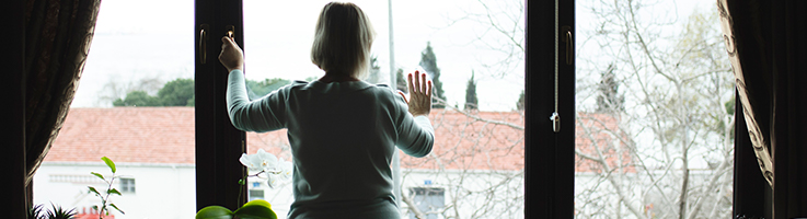 lonely woman putting her hands on window