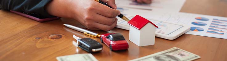 man calculating near model home and car