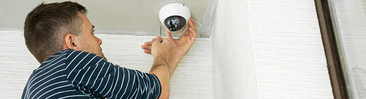 man installing security camera