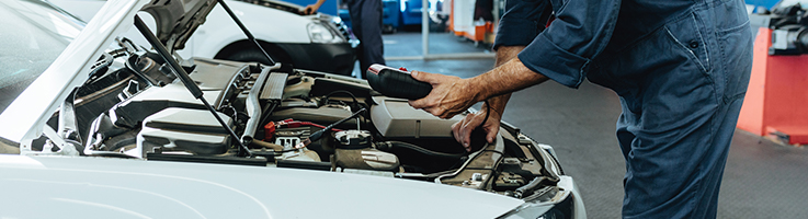 mechanic working under car hood