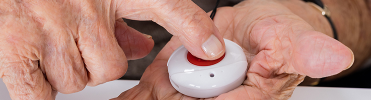 older person pressing a medical alert button