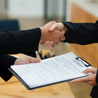 home buyer and agent shaking hands over a closed contract