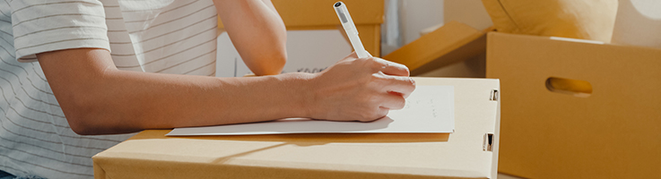 person reviewing a checklist with moving boxes on the background