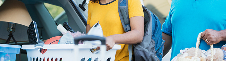 father and daughter loading car with daughter's belongings