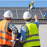 men standing in front of a house in renovation for solar panels