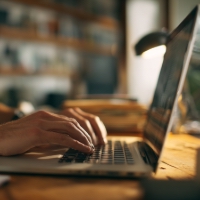 a laptop with someone typing on it
