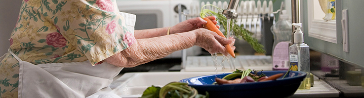 older woman washing vegetables
