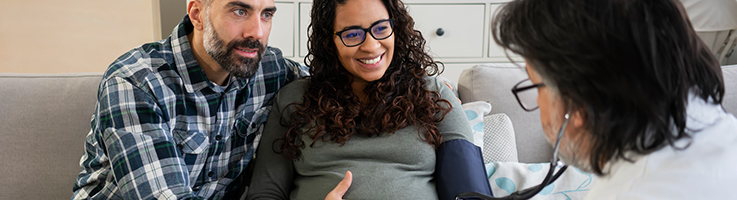 pregnant couple talking to doctor