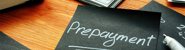 black piece of paper with the word prepayment written in white ink on a table