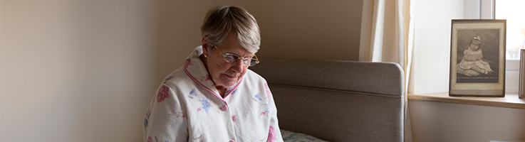 old woman sitting in room alone