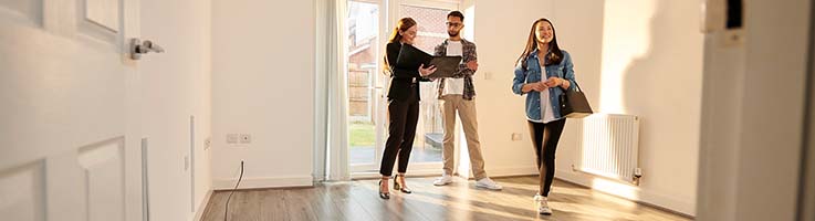 real estate agent showing home to couple