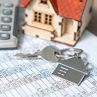 house keys with miniature house and calculator