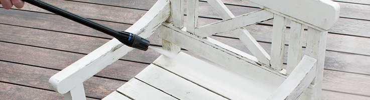 pressure washer cleaning a wooden white chair