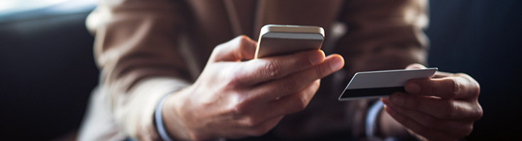 man holding phone and credit card