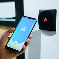 person unlocking their house with home security app