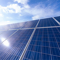 vast number of solar panels with blue sky and clouds above