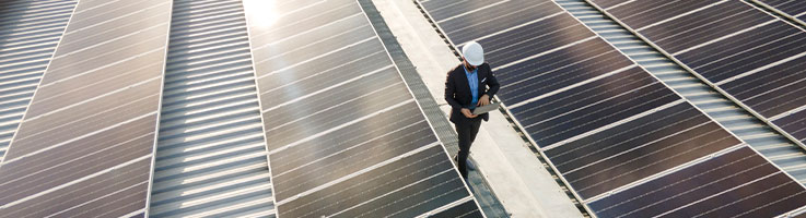 engineer inspecting solar panels on a roof