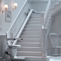 a white stair lift installed at the bottom of some stairs