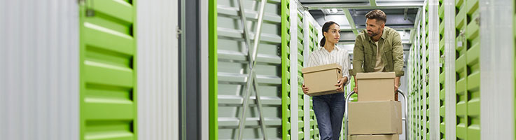 couple moving boxes into storage unit