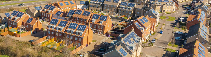 aerial view of a housing development with solar panels on top of roofs