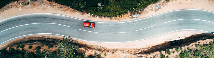 red car driving on road