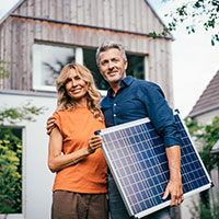 couple holding a solar panel