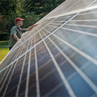 man inspecting solar panels