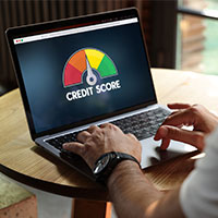 man looking at credit score on laptop screen