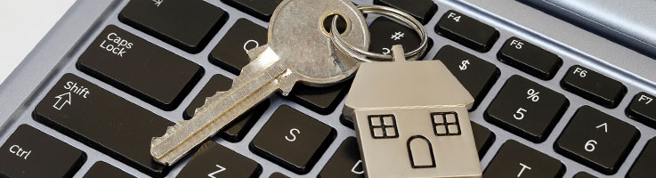 key with metallic house keychain on laptop keyboard