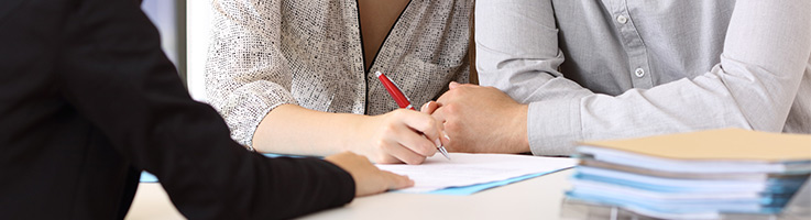 couple signing papers at the banks